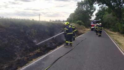 Podél silnice hořela tráva, strážníci s policií museli zastavit dopravu