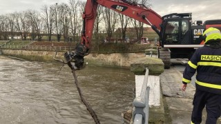 Takto odklízeli hasiči naplavené klády pod mostem v Pražské ulici v Terezíně. Nejvíce zásahů si připsali hasiči na Děčínsku a Ústecku. Foto: HZS Ústeckého kraje